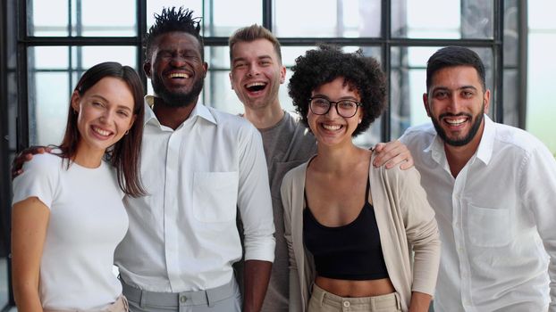 Portrait of successful creative business team looking at camera and smiling. Diverse business people standing together at startup.