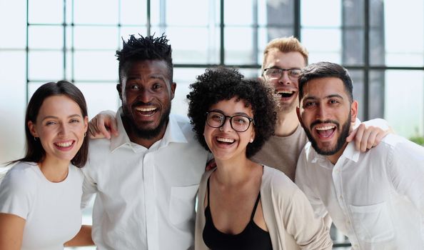 Portrait of successful creative business team looking at camera and smiling. Diverse business people standing together at startup.