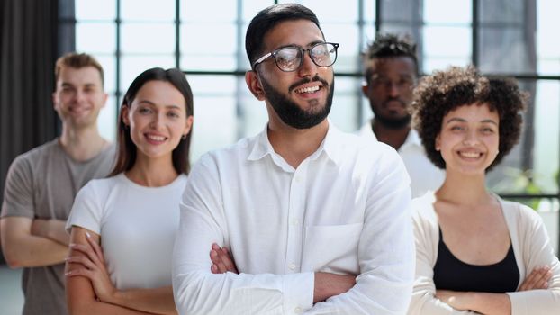 Portrait of successful creative business team looking at camera and smiling. Diverse business people standing together at startup.