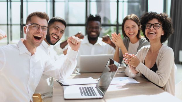 Portrait of successful creative business team looking at camera and smiling. Diverse business people standing together at startup.