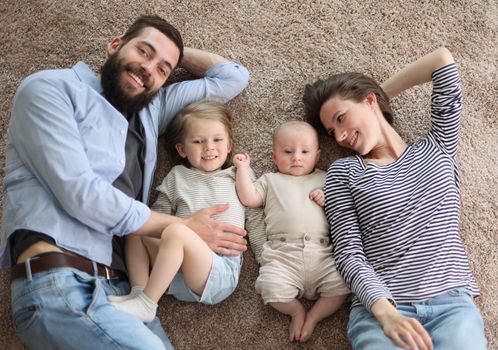 happy family mother father and kids at home. laying