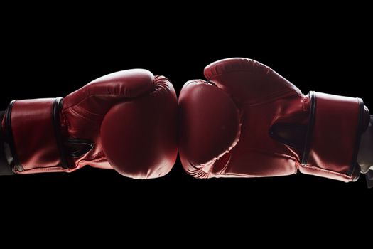 Two men's hands in boxing gloves. The concept of confrontation. Photo on a black background
