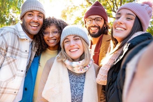 Large group of friends take a selfie photo smiling at the camera. Laughing young people celebrating standing outside and having fun. Portrait photography of guys and girls enjoying their vacation