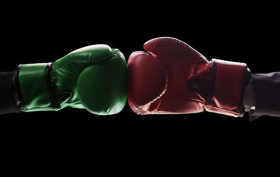 Two men's hands in boxing gloves. The concept of confrontation. Photo on a black background