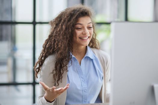 expressive young woman open mouth checking discounts for online shopping sitting at desktop .