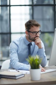 Young cheerful businessman working at office