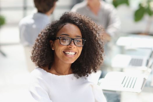 young attractive african american woman in the office sitting at the table