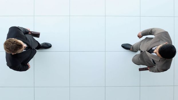 Two businessmen shake hands. view from above