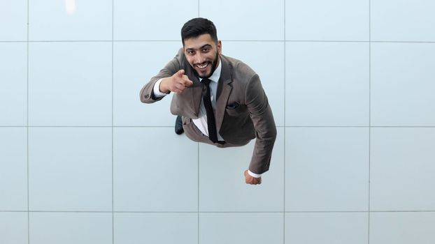 Handsome smiling business man in a suit standing with his arms crossed. View from above