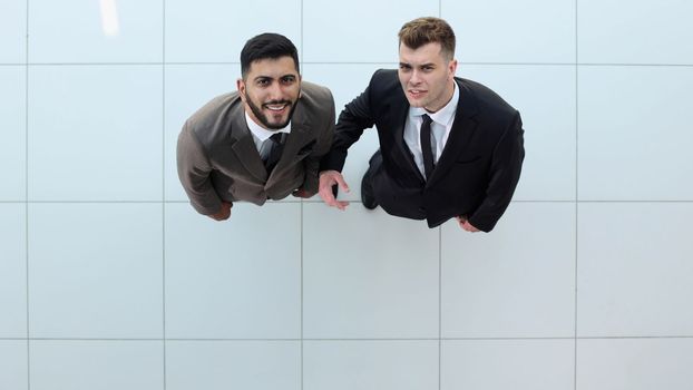 Portrait of two concentrated businessmen partners dressed in formal suit walking and having conversation during working meeting