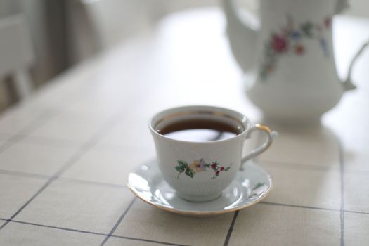 antique porcelain tea set on white background. cup of tea and a kettle on a table.