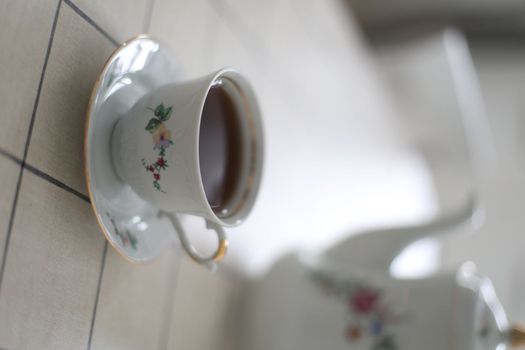 antique porcelain tea set on white background. cup of tea and a kettle on a table.