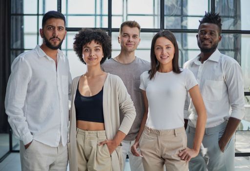Portrait of successful creative business team looking at camera and smiling. Diverse business people standing together at startup.