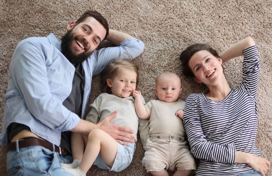 happy family mother father and kids at home. laying
