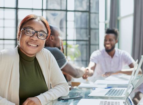 Portrait Of Businesswoman In Modern Open Plan Office With Business Team Working In Backgroun