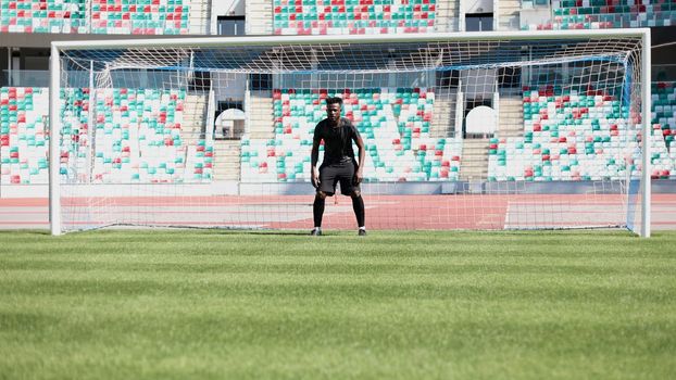 Football goalkeeper catches the ball in the stadium. game concept