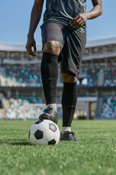 feet of soccer player tread on soccer ball in the stadium