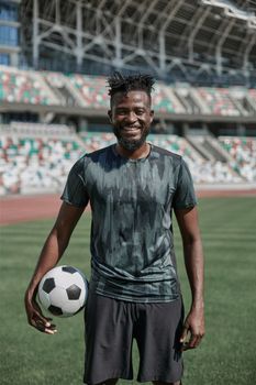 Intense portrait of a football player holding the ball in the stadium