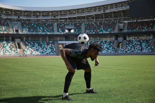 one football player is training holding the ball with his back. African American football player in training.