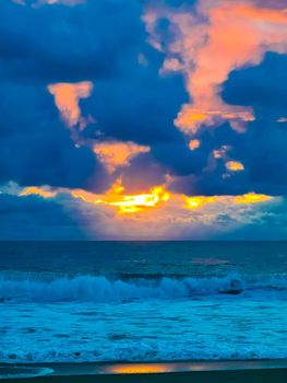 Beautiful stunning colorful and golden sunset in yellow orange red on beach and big wave panorama in tropical nature in Zicatela Puerto Escondido Oaxaca Mexico.