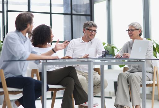 Serious team of professionals, business people negotiating in modern boardroom, discuss project
