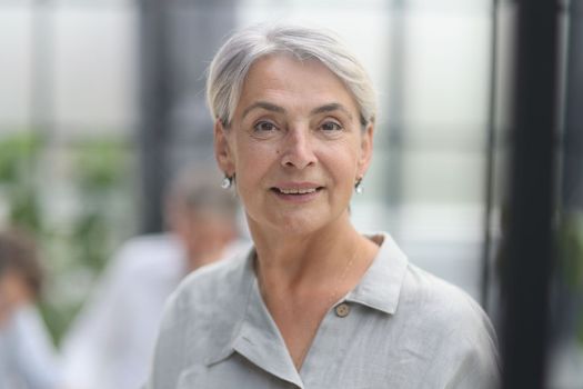 close-up mature woman holding a cup in the office.