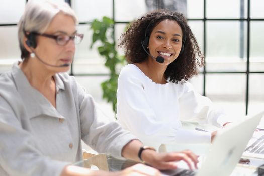 Young friendly operator woman agent with headsets working in a call centre