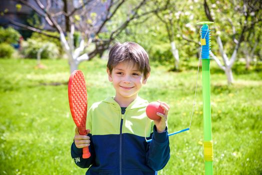 Happy boy is playing tetherball swing ball game in summer camping. Happy leisure healthy active time outdoors concept.