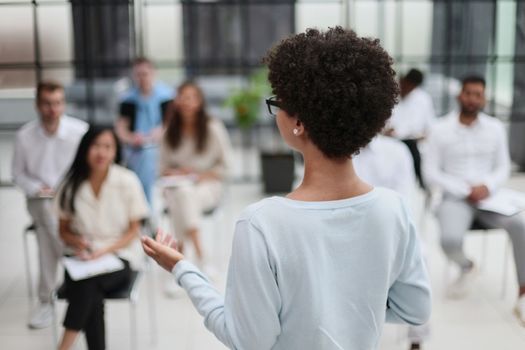 Selective focus of young businesswoman together with interracial colleagues during seminar