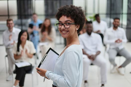 Selective focus of young businesswoman together with interracial colleagues during seminar