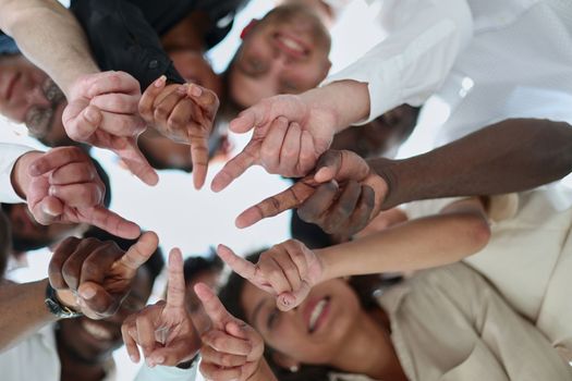 group of diverse young people standing in a circle and looking down