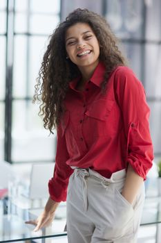 Image of young beautiful joyful woman smiling while working with laptop in office