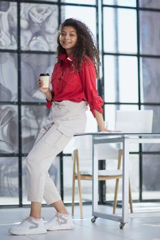 Im ready to start the day. an attractive young businesswoman standing alone in the office with her arms folded