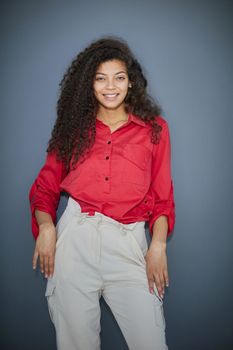 Happy young business woman posing isolated over grey wall background.