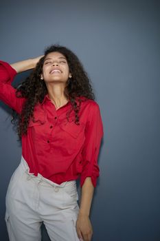 Happy young business woman posing isolated over grey wall background.