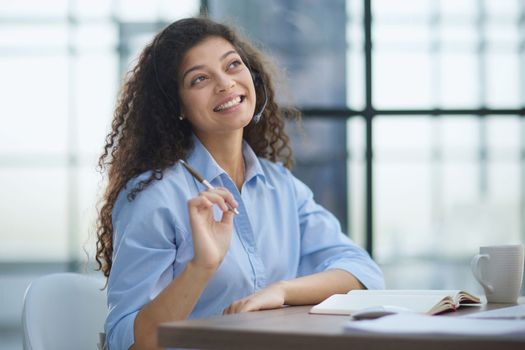 Portrait of an attractive cheerful experienced girl advising clients on customer service in the office