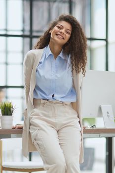 Young business woman standing at the table with a serious expression making