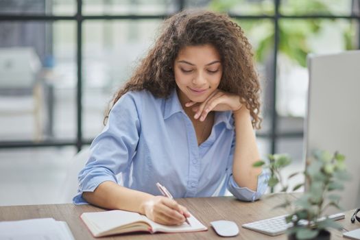 Business woman holding pens and papers making notes in documents on the table