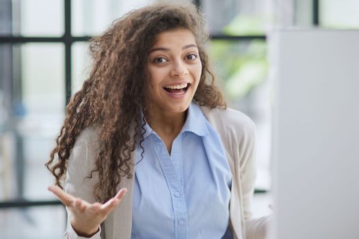 expressive young woman open mouth checking discounts for online shopping sitting at desktop .