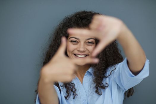 Photo of cheerful self-assured lady folded arms wear blue shirt grey color background