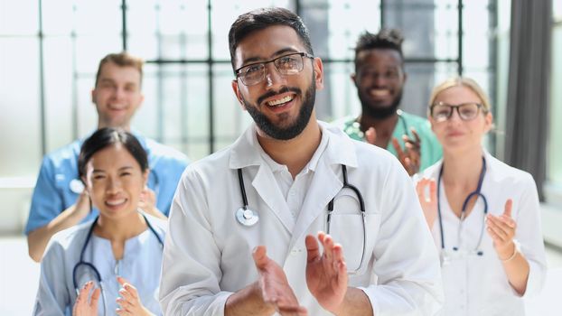 Successful team of young doctors clapping their hands