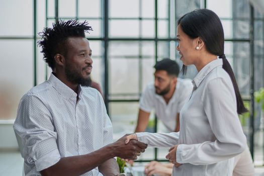 Handshake between business man and woman indoors.