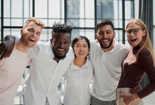 Portrait of successful creative business team looking at camera and smiling. Diverse business people standing together at startup.