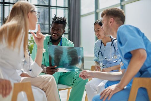 Young group of oral surgeons looking at x-ray while preparing for surgery procedure.