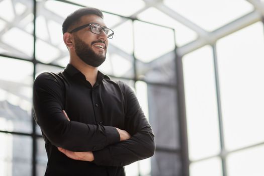 Businessman portrait. Happy confident young businessman standing , smiling, looking at camera.