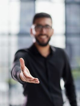 smiling businessman reaching out for a handshake