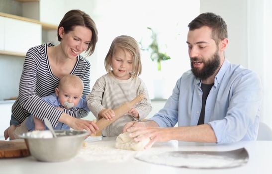 Young family with daughter and son in the kitchen