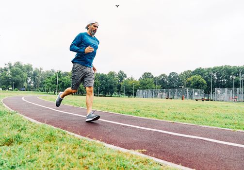 portrait of a senior man exercising and running outdoors