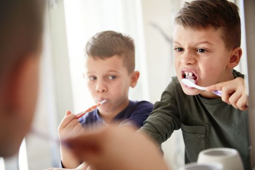 Little cute brothers washing teeth in the bathroom