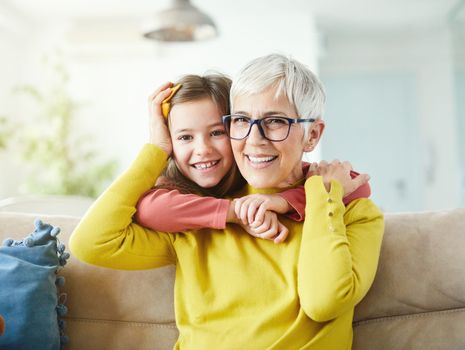 Portrait of Grandmother and granddaughter having fun together at home